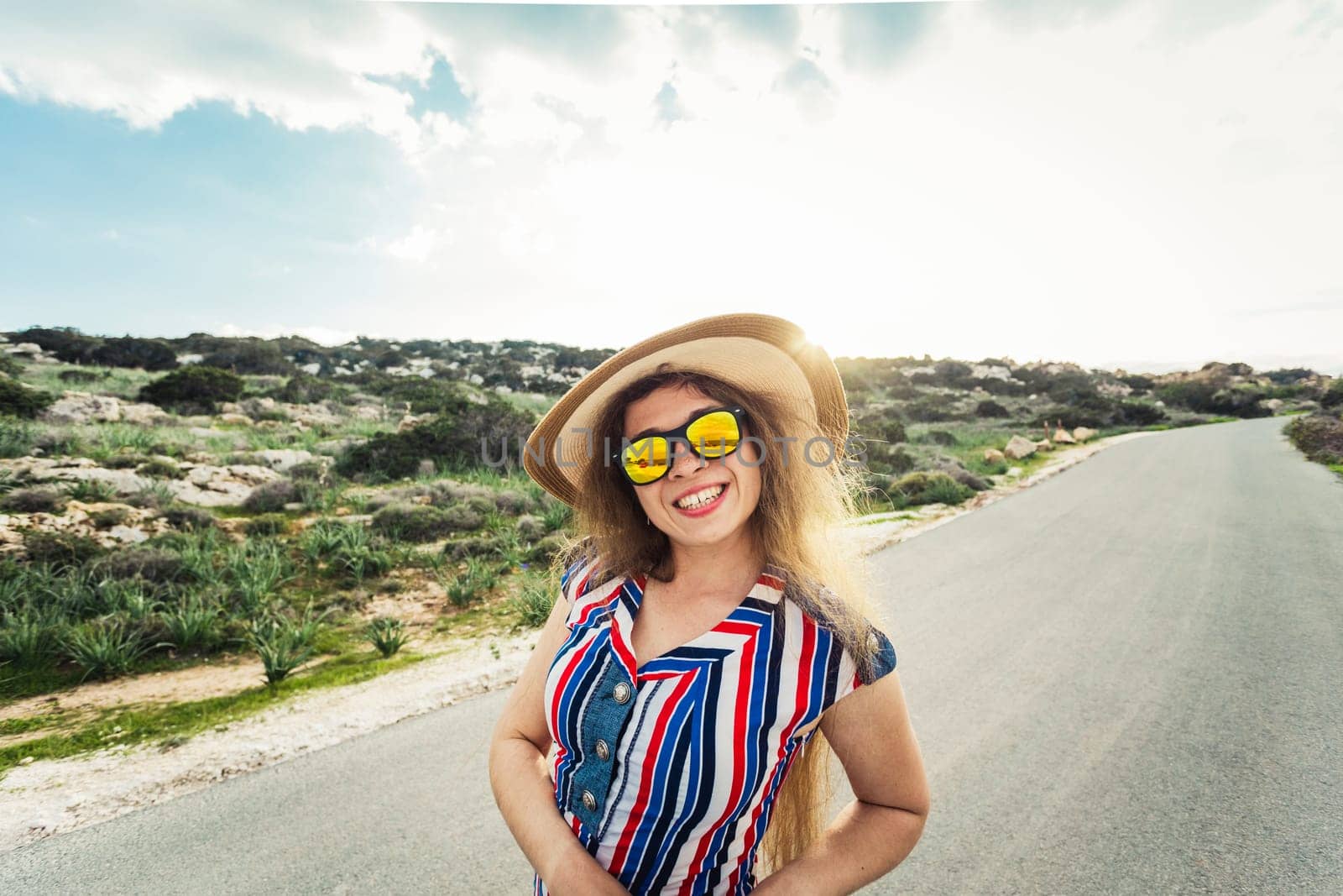 smiling woman on vacation with sun hat and glasses.
