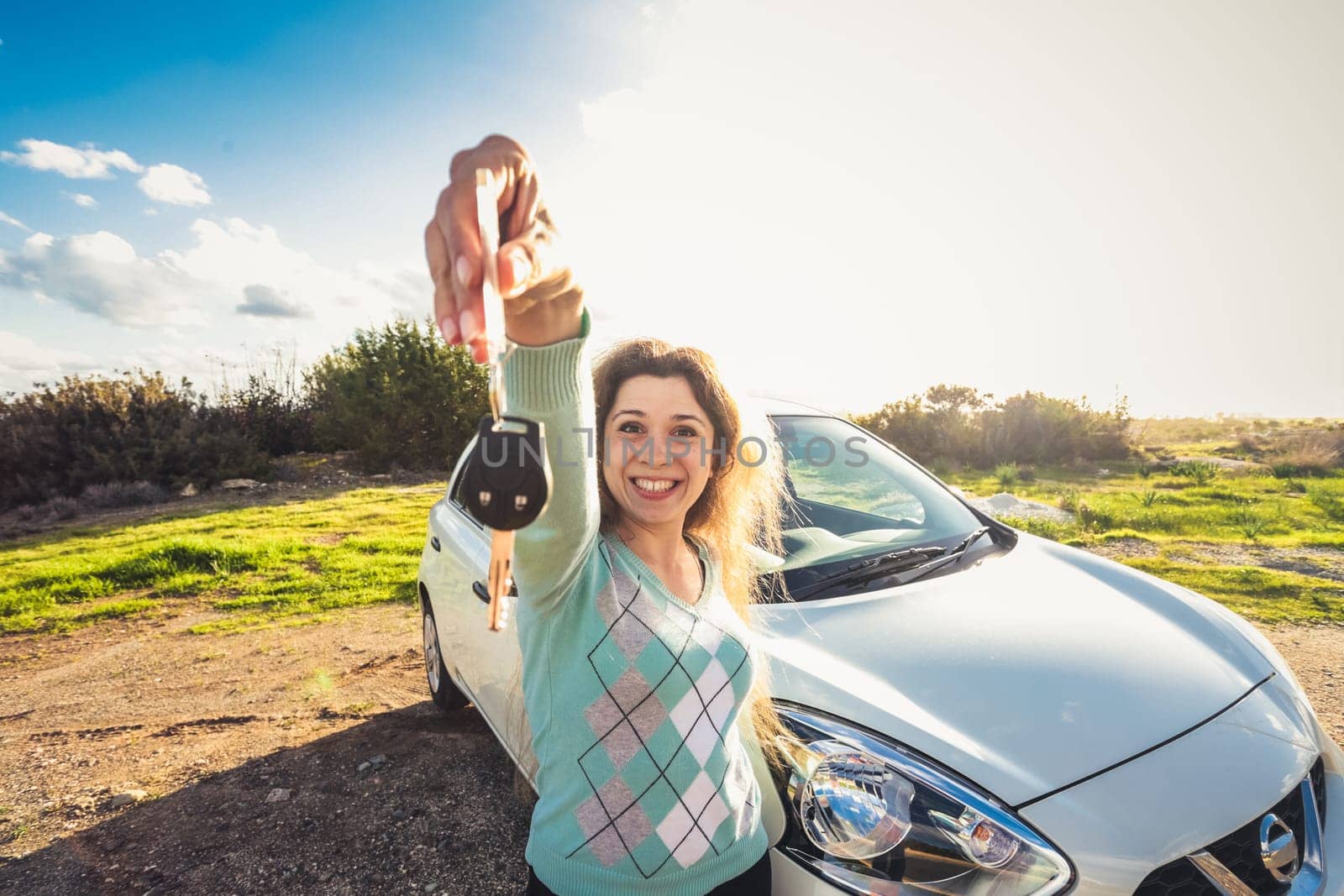 happy woman driver hold car keys near her new car.