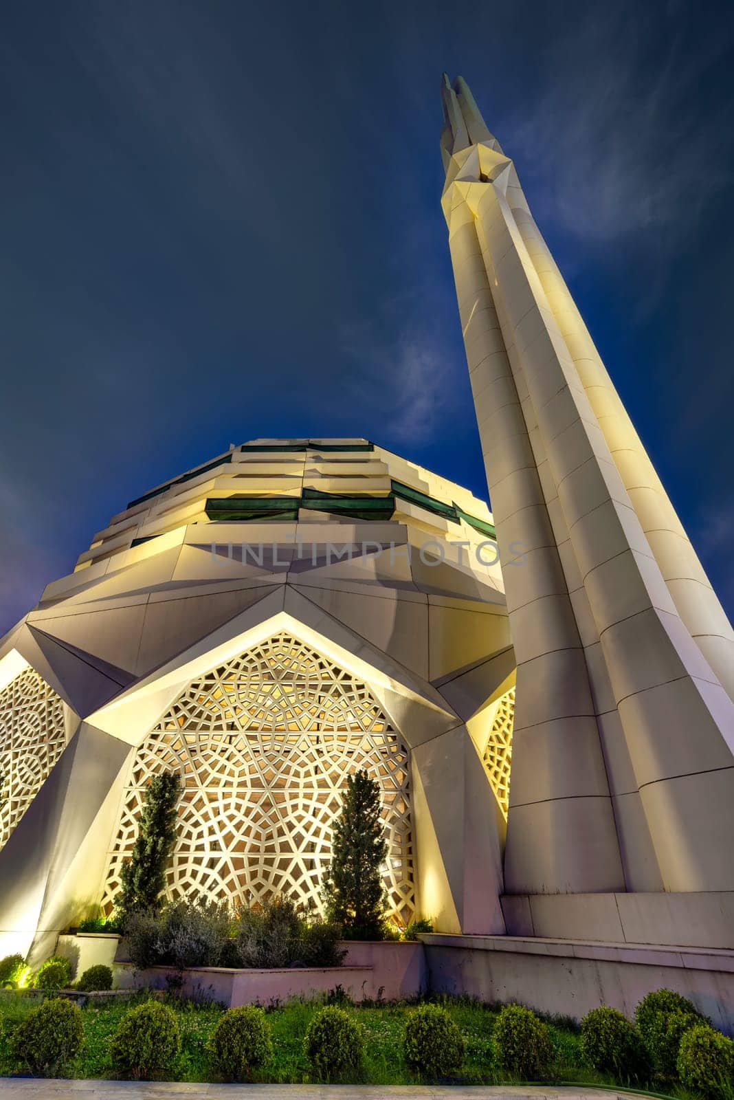 Mosque of Faculty of Theology, Marmara University, radiantly illuminated against the backdrop of a serene night sky, with a towering minaret, reaching towards the sky, Uskudar, Istanbul, Turkey