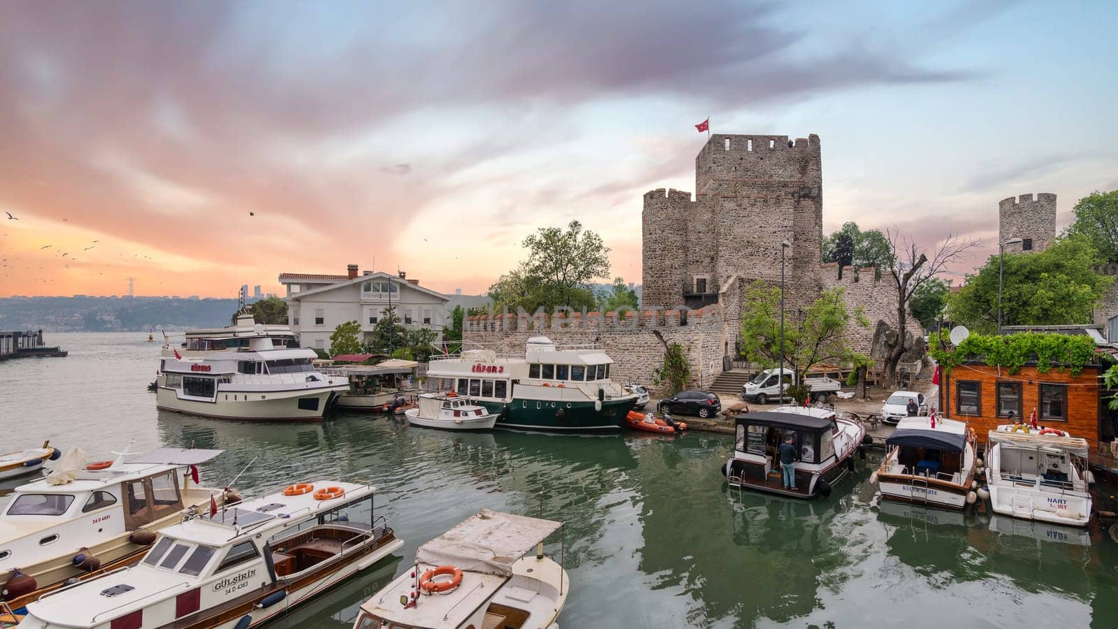 Goksu Stream, with docked group of different shapes, sizes and colors boats, beside Anadolu Hisari historic castle on the Anatolian side of the Bosporus in Beykoz district, Istanbul, Turkey