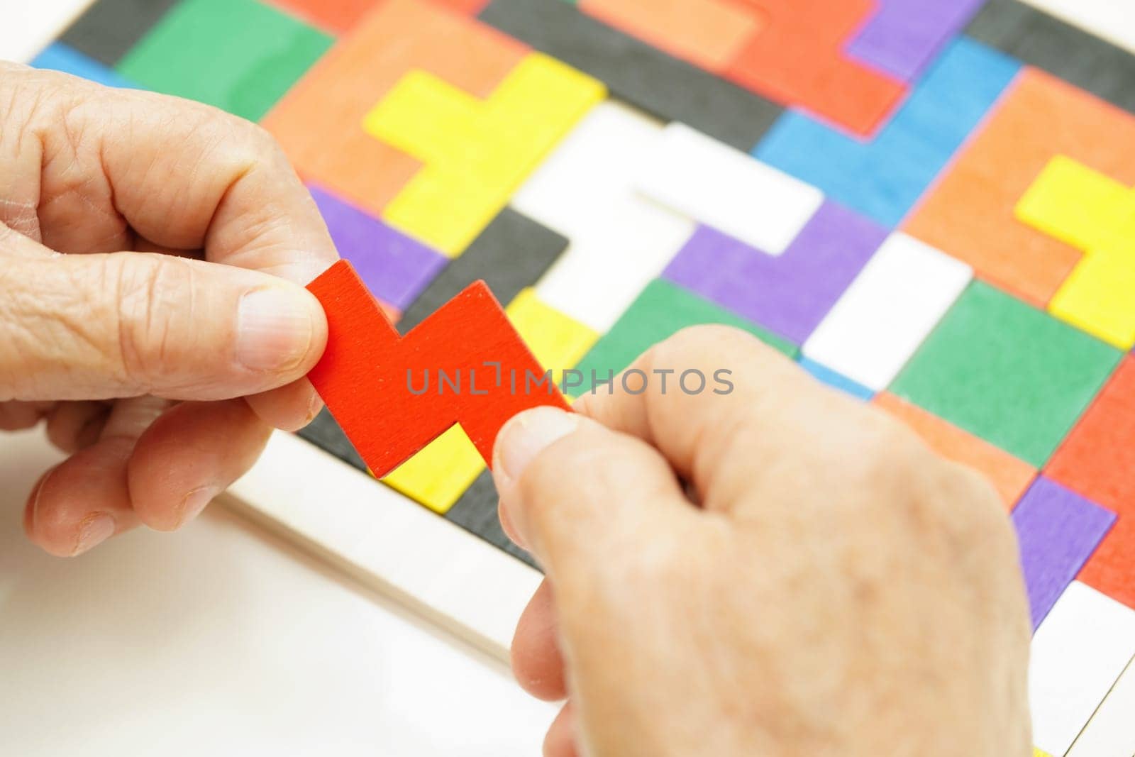 Asian elderly woman playing puzzles game for treatment dementia prevention and Alzheimer disease.