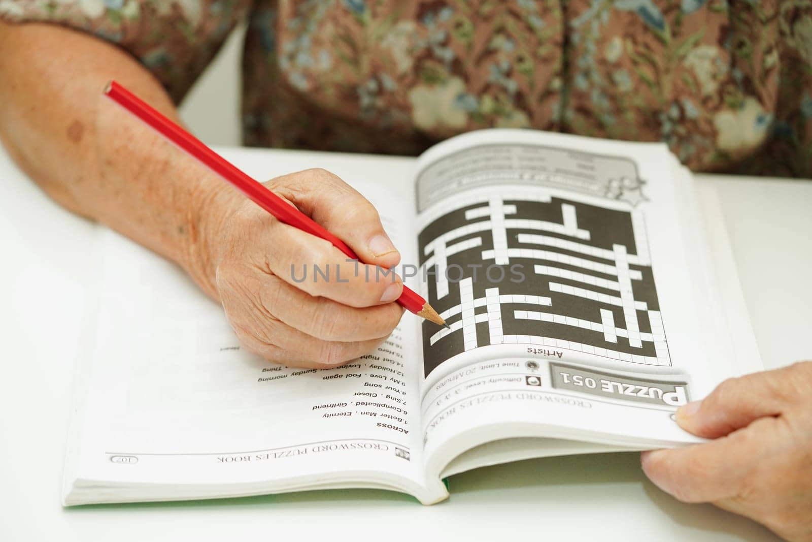 Bangkok, Thailand - May 15, 2022 elderly woman playing sudoku puzzle game for treatment dementia prevention and Alzheimer disease.