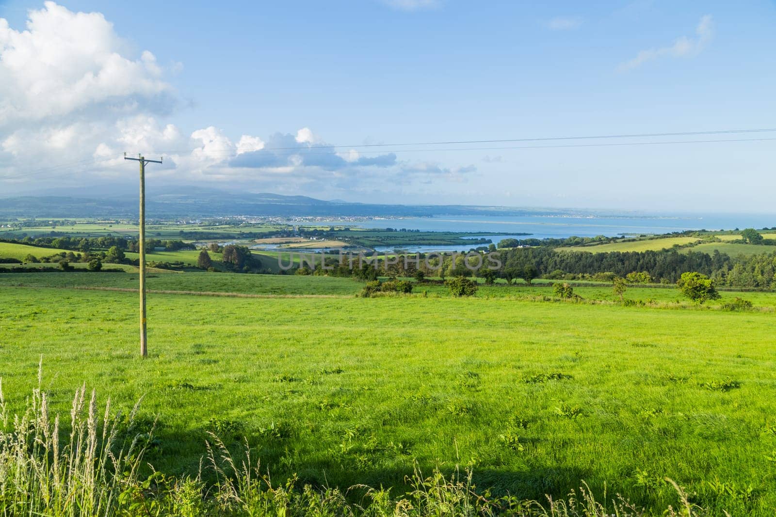 Stunning view over countryside, fields, hills and the sea near Dungarvan, Ireland.