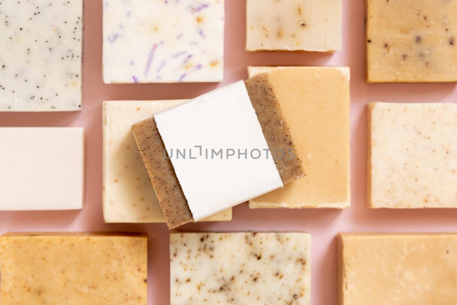 Beige and brown handmade soap bars on light pink top view, soap packaging mockup, copy space. Natural herbal products for for face and body care. Using organic handmade skincare products
