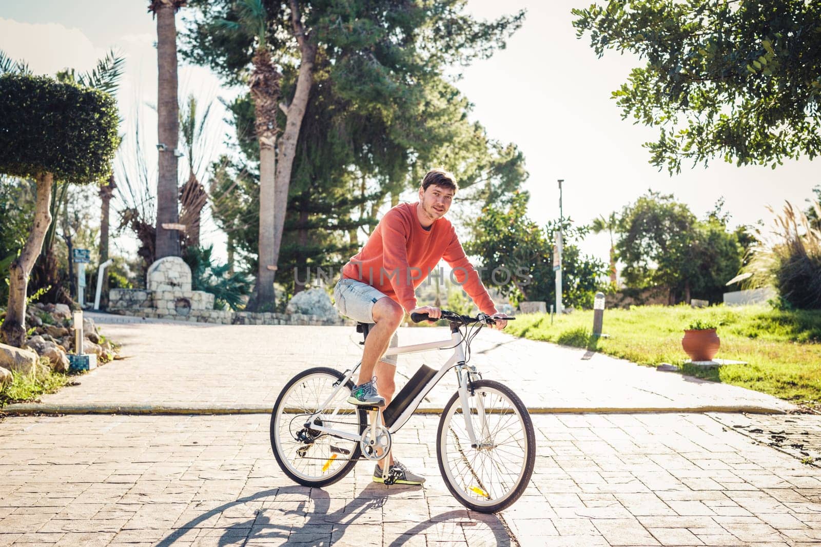 Portrait of handsome guy riding bicycle in the park.
