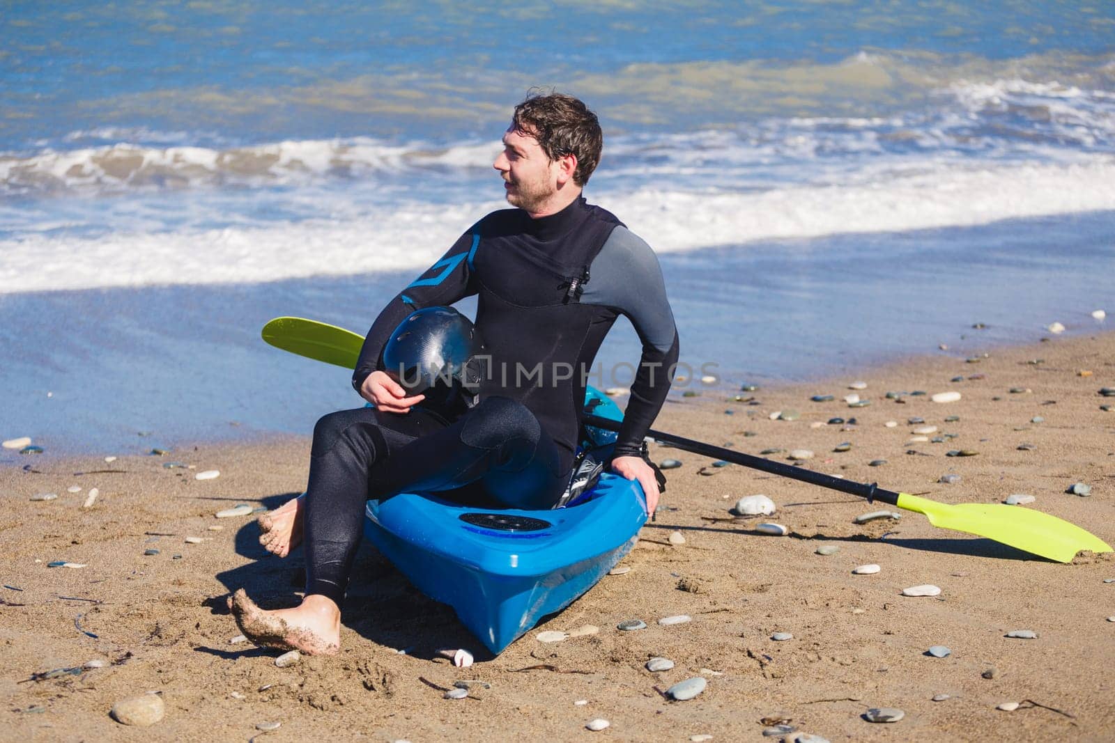 Man with kayak on the beach in sunny day.