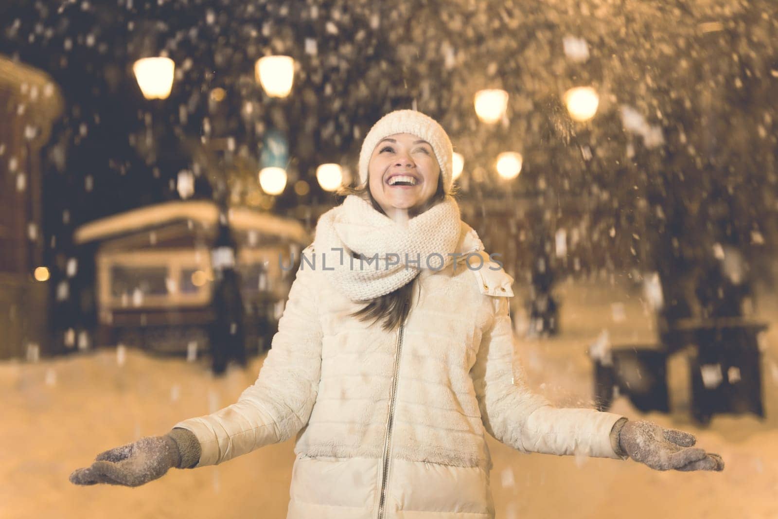 Girl in a night city snowflake Christmas city lights. Christmas and winter holidays.
