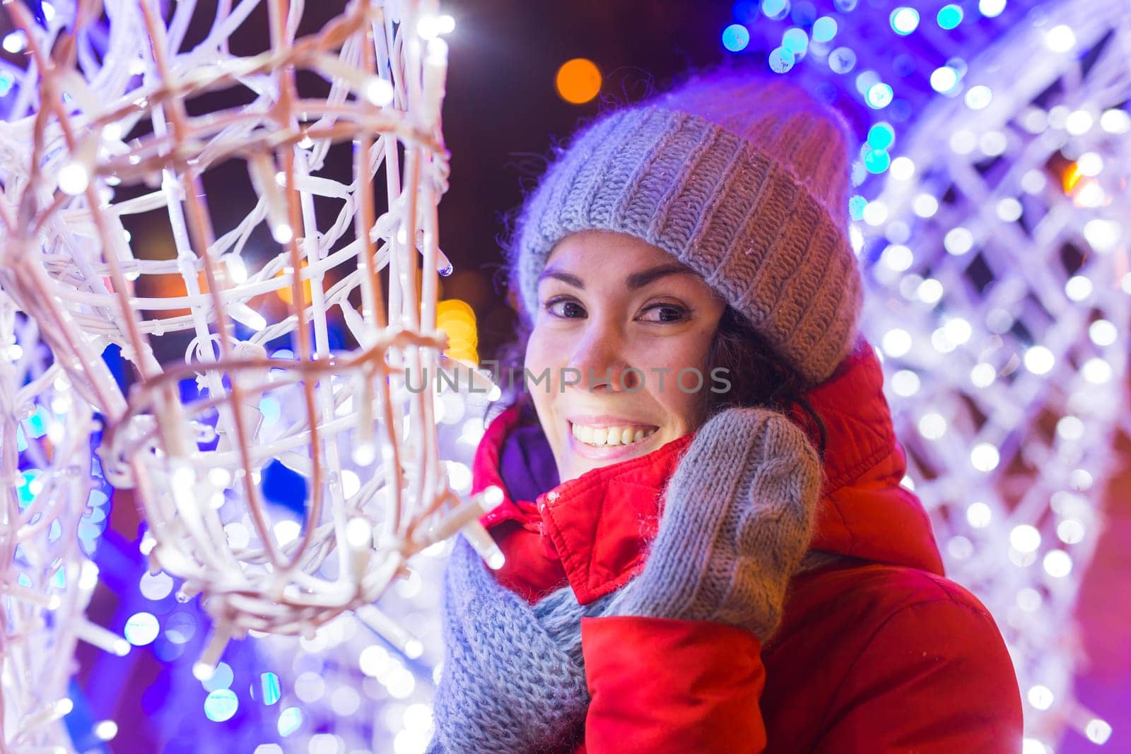 Portrait of young funny attractive woman over snowy Christmas background. Winter holidays and season.