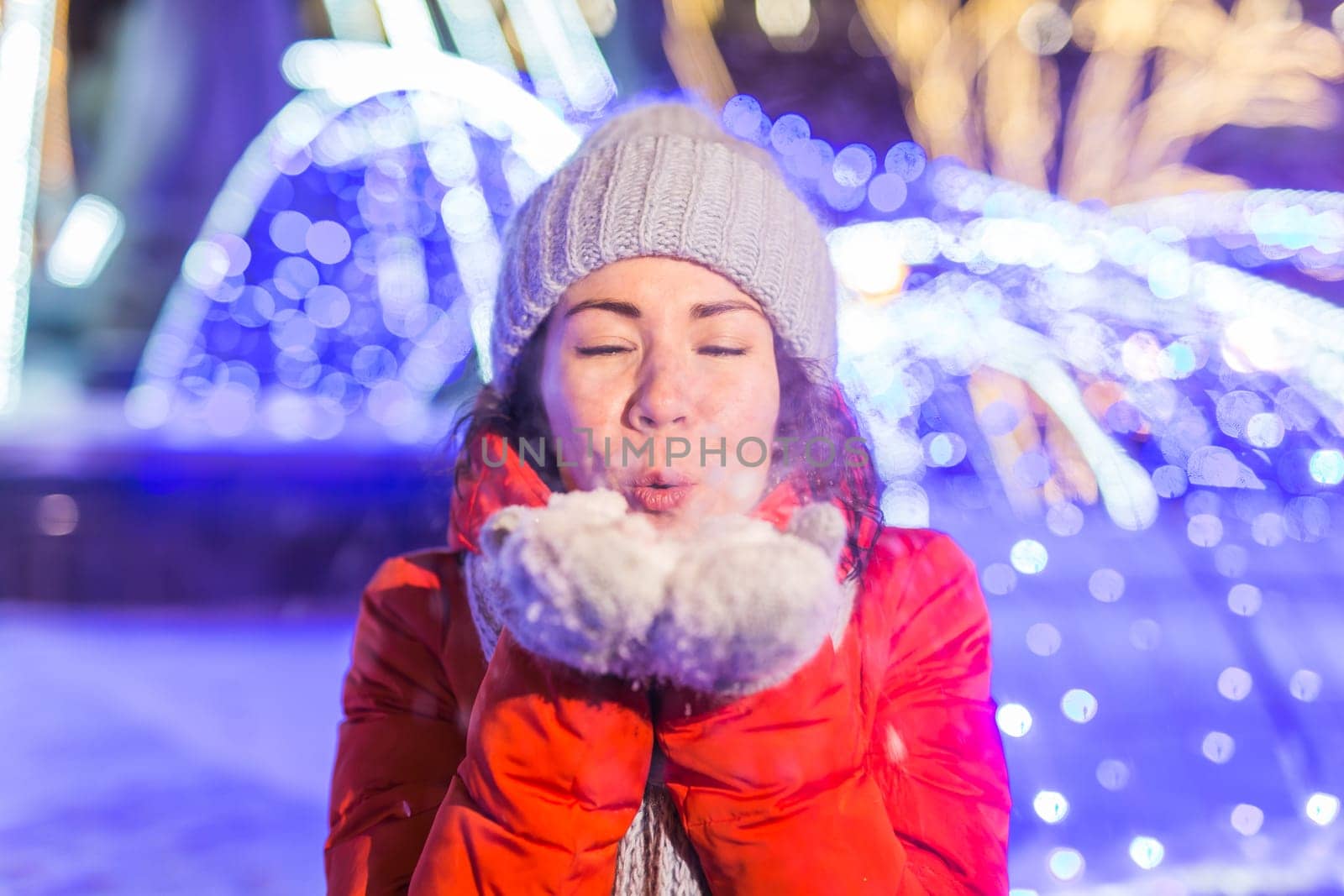Portrait of young funny attractive woman over snowy Christmas background. Winter holidays and season.