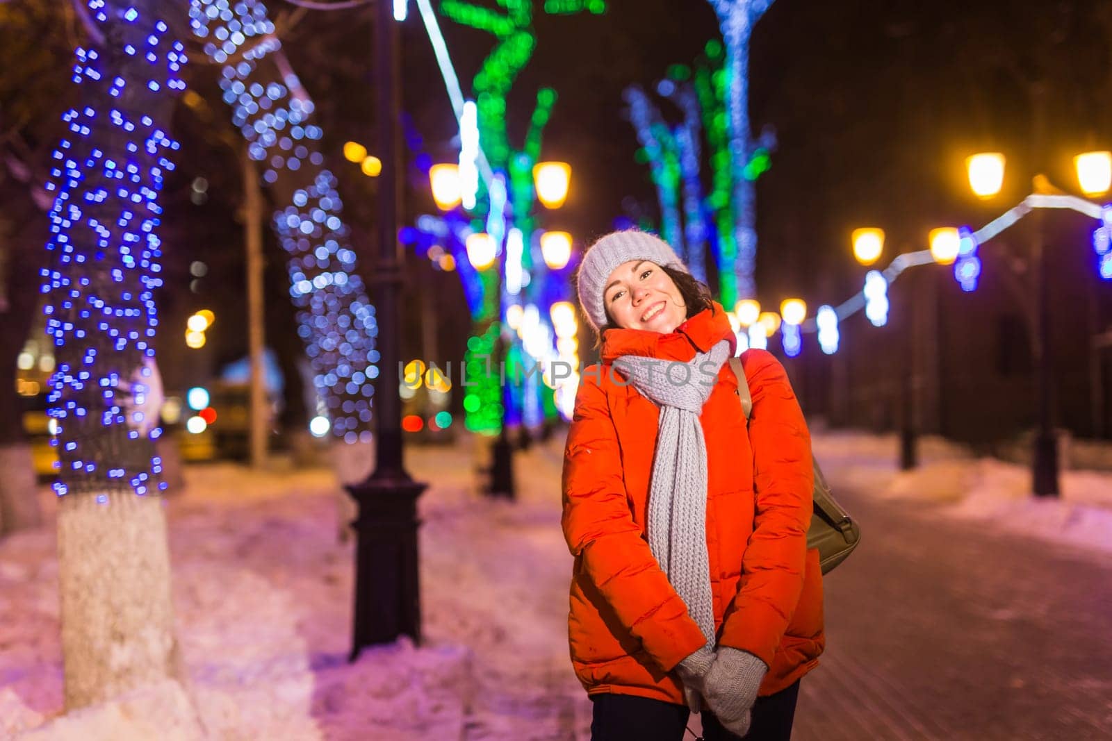 Girl in a night city snowflake Christmas city lights. Christmas and winter holidays.
