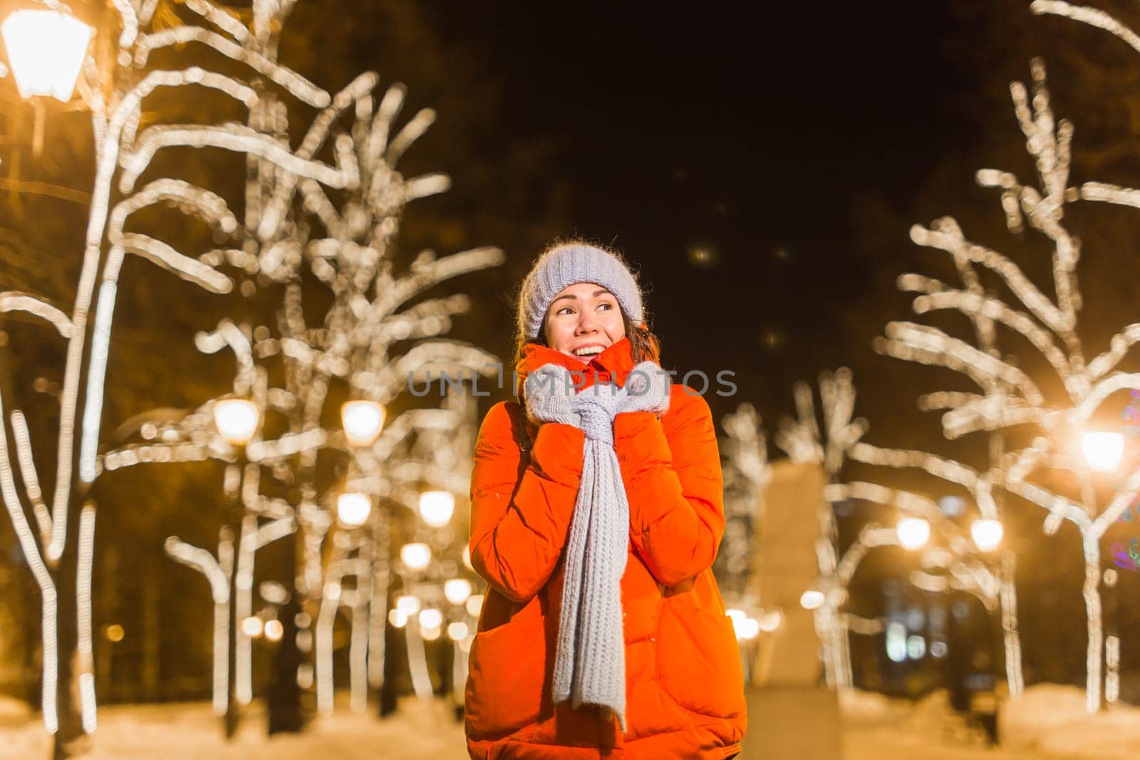 Portrait of young funny attractive woman over snowy Christmas background. Winter holidays and season.