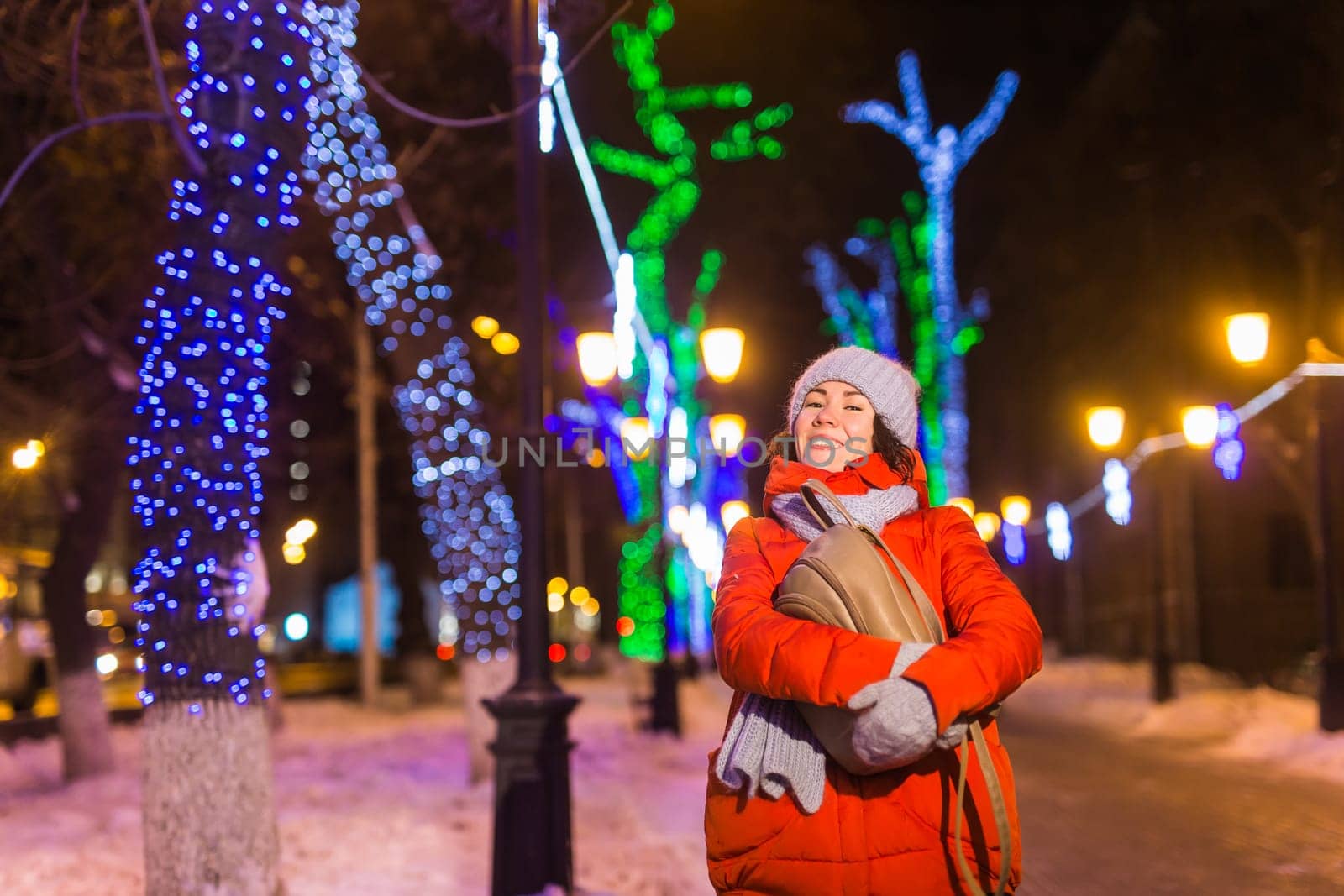 Girl in a night city snowflake Christmas city lights. Christmas and winter holidays.