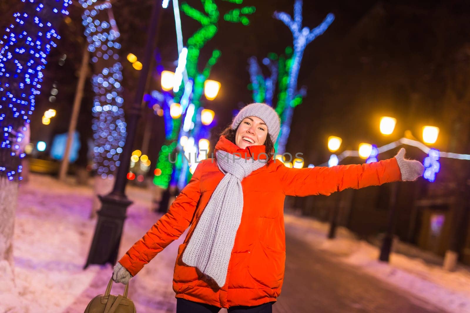 Girl in a night city snowflake Christmas city lights. Christmas and winter holidays.