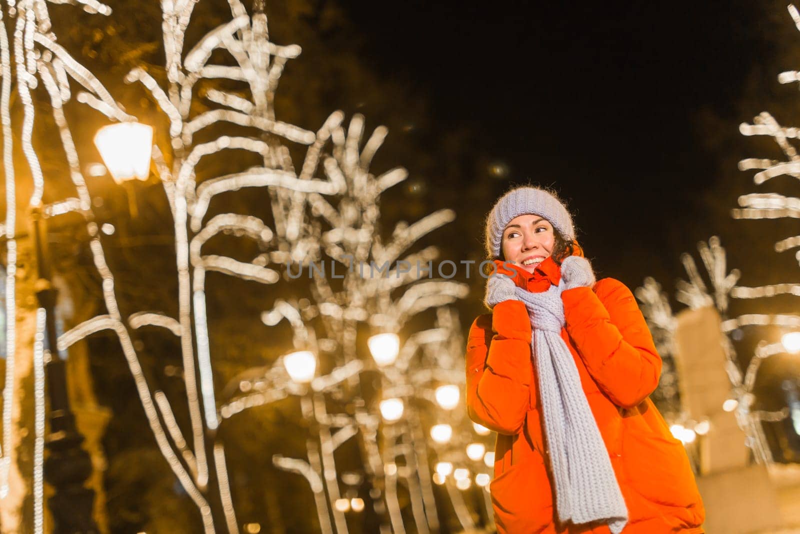 Girl in a night city snowflake Christmas city lights. Christmas and winter holidays.