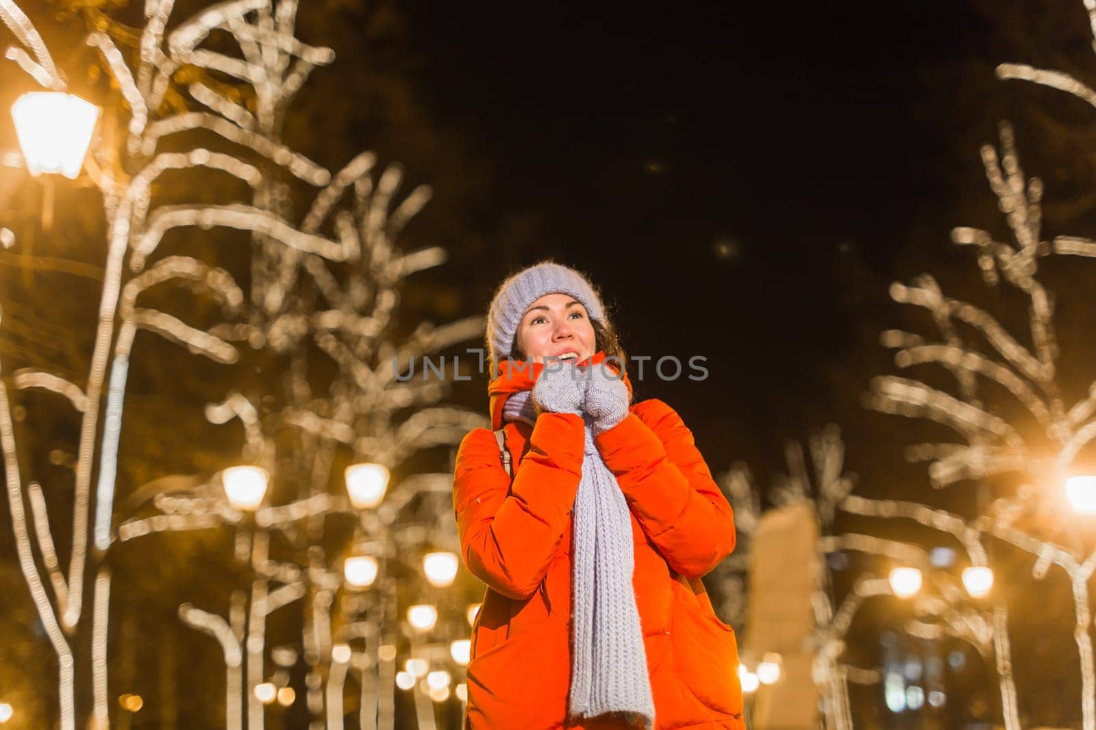 Portrait of young funny attractive woman over snowy Christmas background. Winter holidays and season.