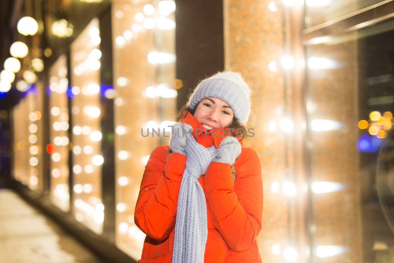 Portrait of young funny attractive woman over snowy Christmas background. Winter holidays and season.