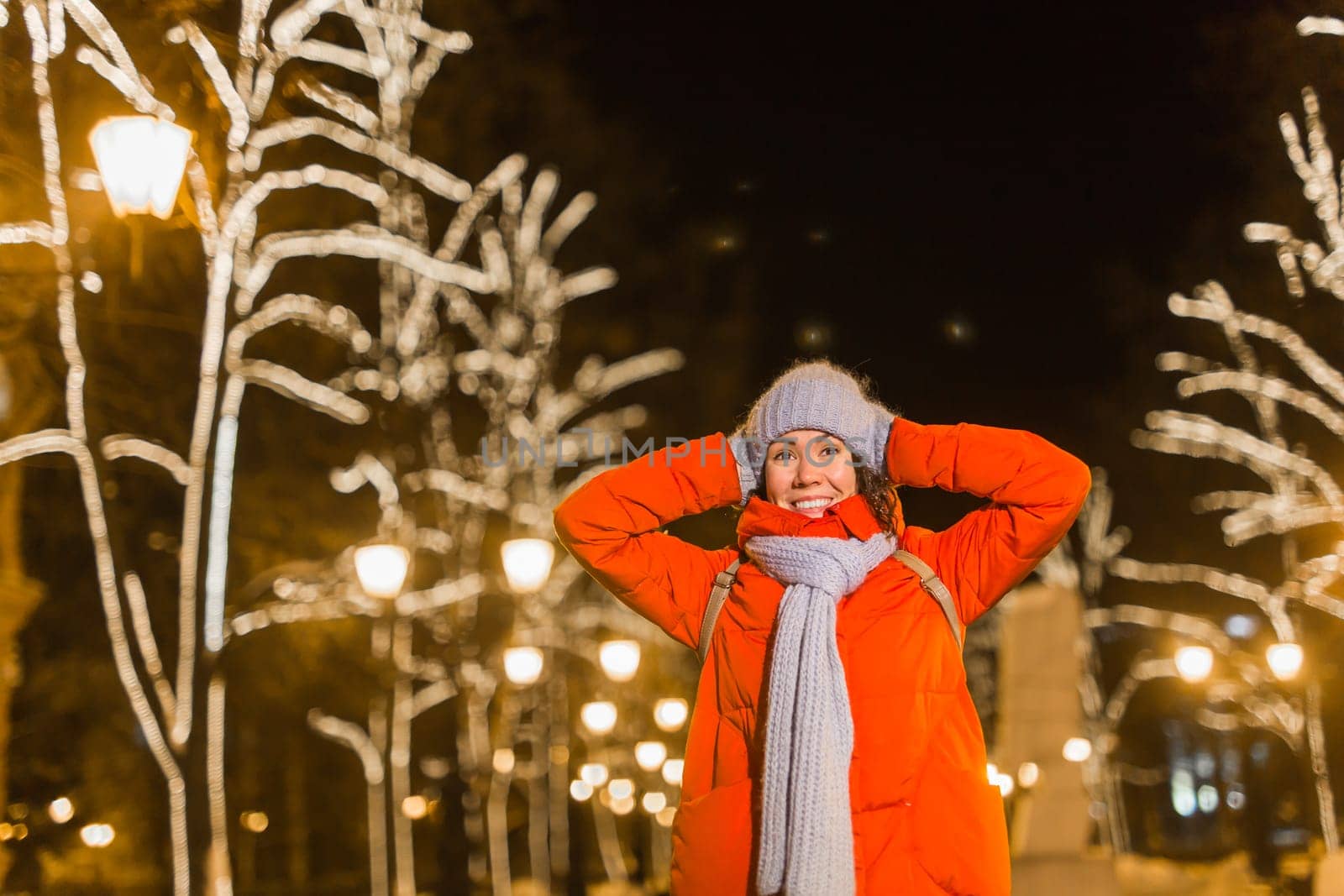 Portrait of young funny attractive woman over snowy Christmas background. Winter holidays and season.