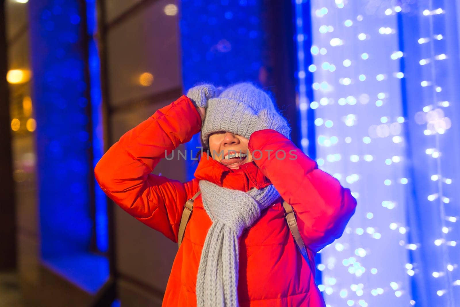 Girl in a night city snowflake Christmas city lights. Christmas and winter holidays.