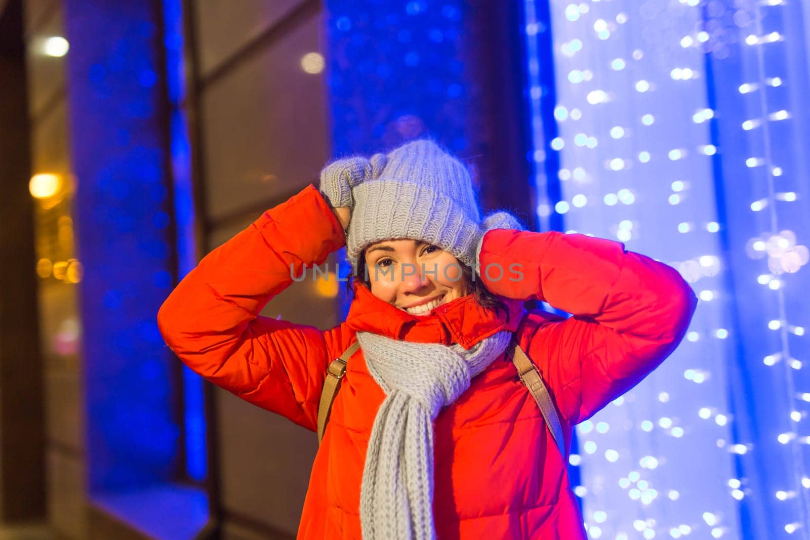 Portrait of young funny attractive woman over snowy Christmas background. Winter holidays and season.