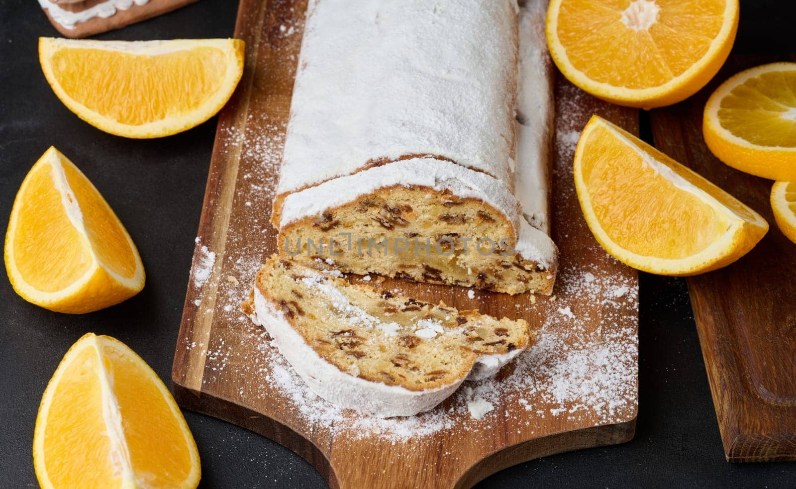 Christmas pastries stollen sprinkled with powdered sugar on the table, festive dessert
