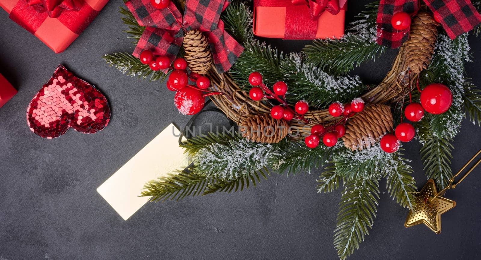 Christmas wreaths, fir branches and gifts on a black background. View from above