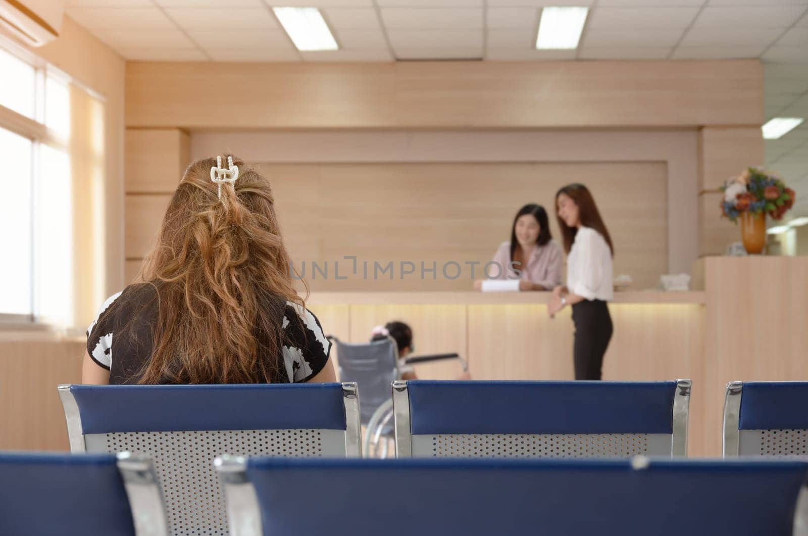 Patient sitting in hospital lobby and waiting for doctor check up or medical examination results. Healthcare, medicine and insurance concept