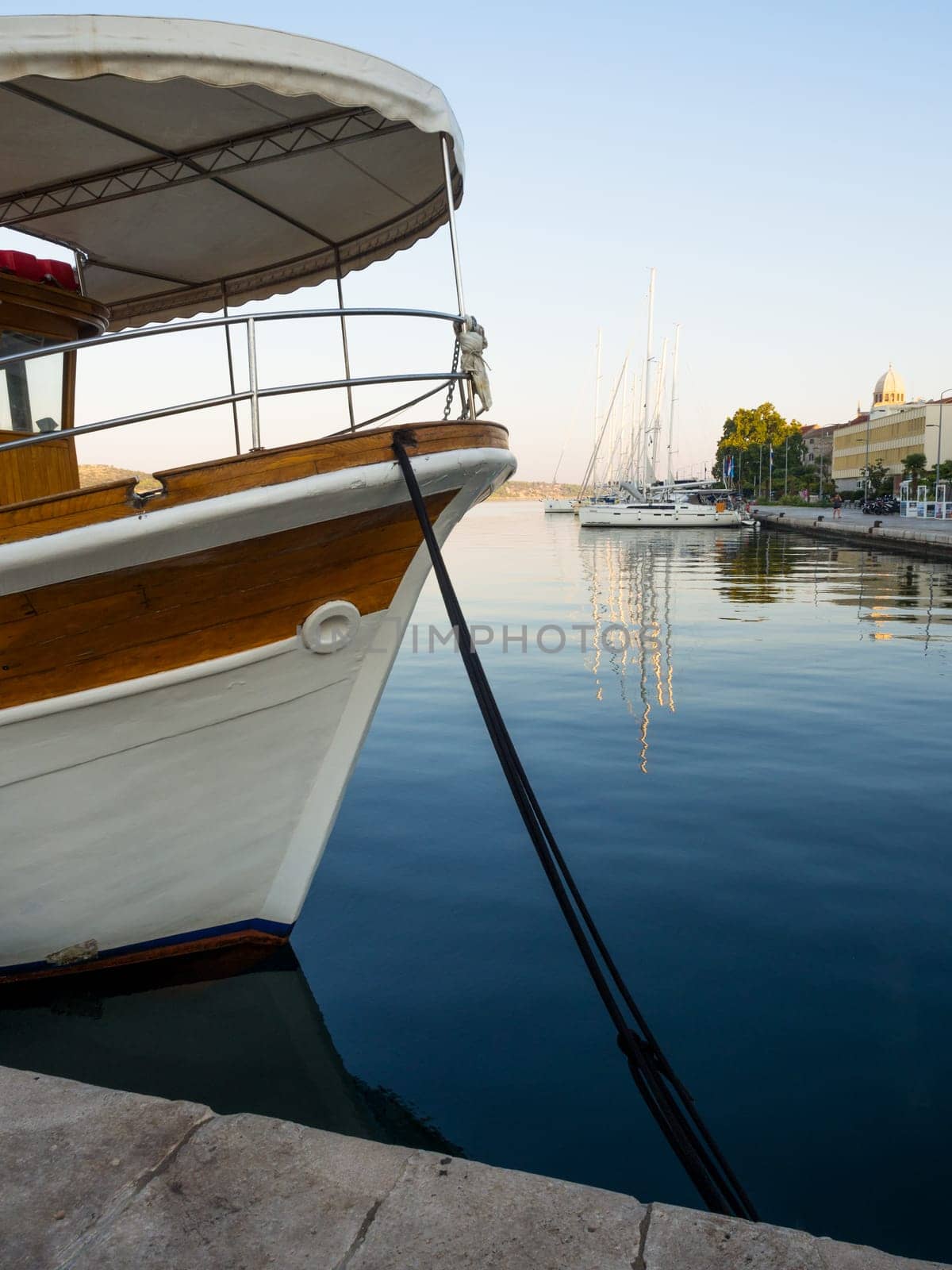 Sailing ships moored in the waterfront marina of Šibenik, Croatia at sunset