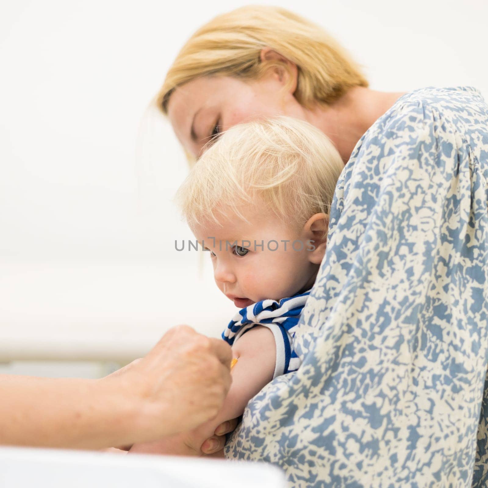 child beeing vaccinated by pediatrician in presence of his mother. Preventive vaccination against Diphtheria, whooping cough, tetanus, hepatitis, haemophilus influenzae, pneumococcus, poliomyelitis.