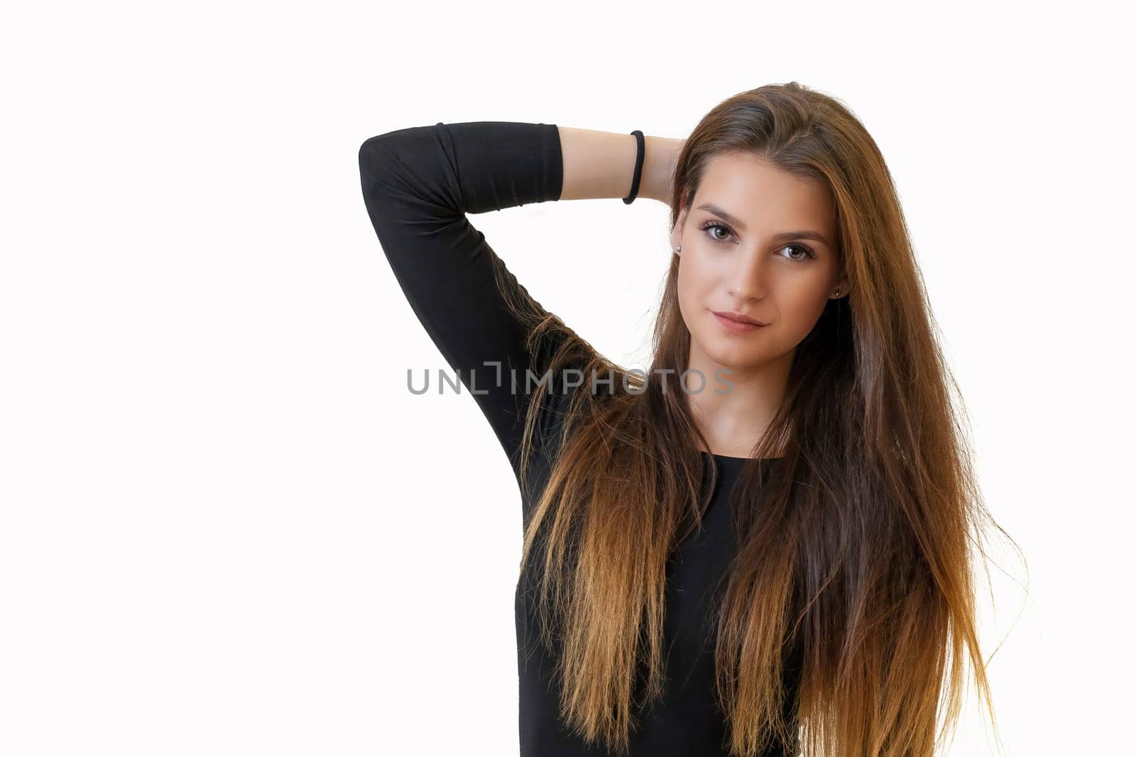 Studio portrait of attractive girl holding her long hair on the light background. Horizontally.
