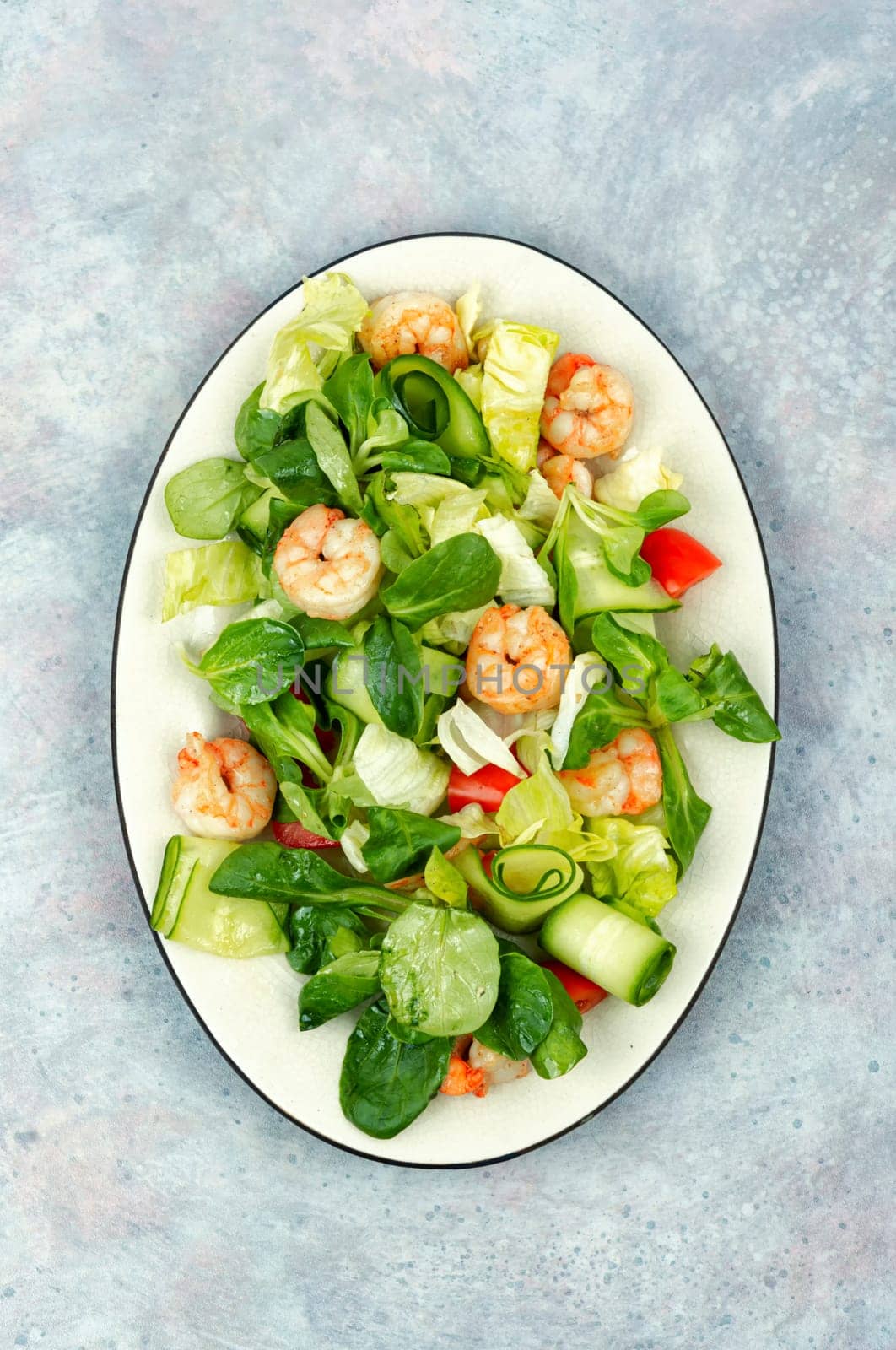 Plate with appetizing shrimps salad with green lettuce. Salad of shrimp or prawns. Healthy eating.