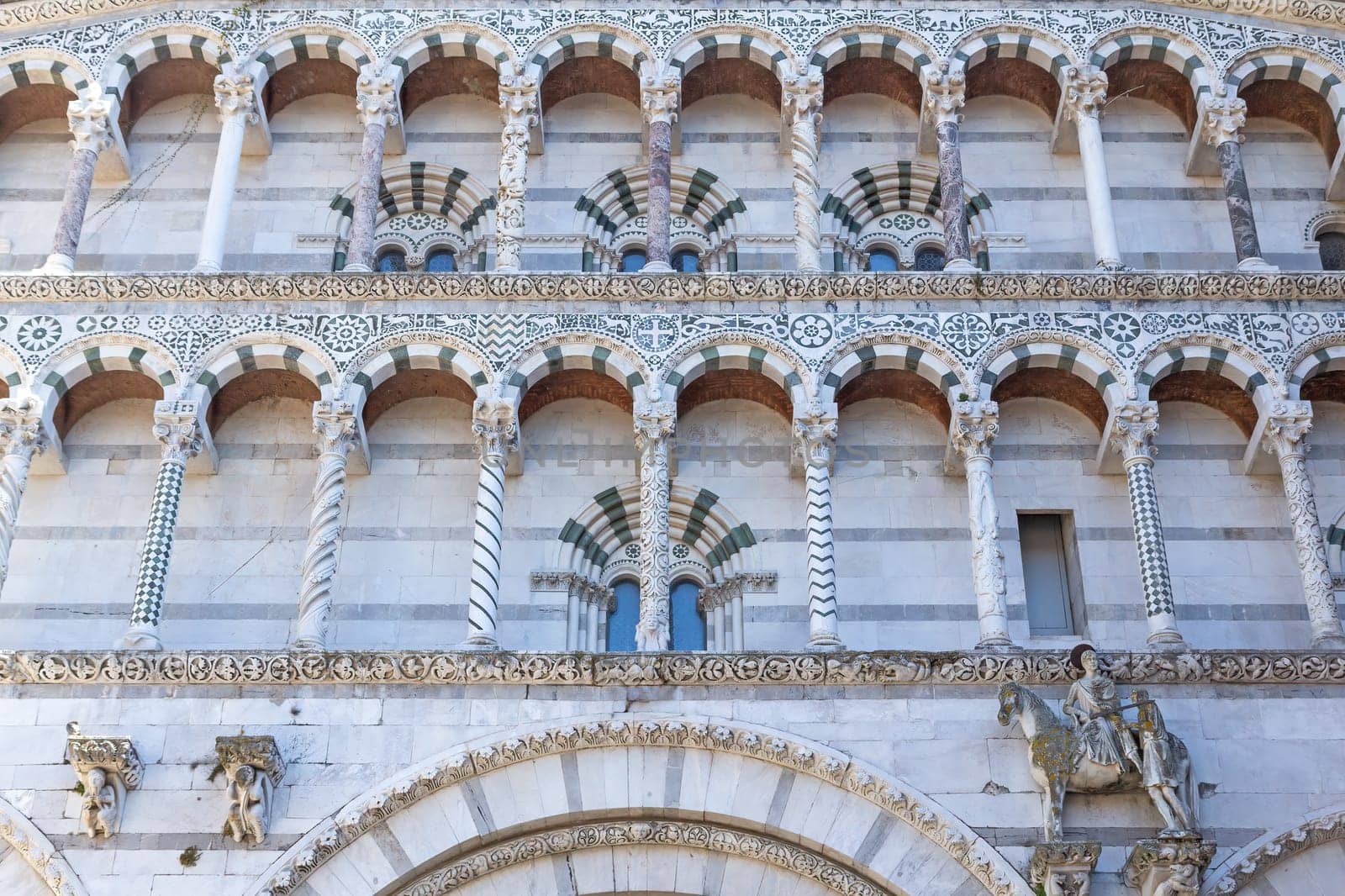 Closeup view of a columned marble facade decoration of the cathedral of St. Martin. (Lucca, Italy). Horizontally.