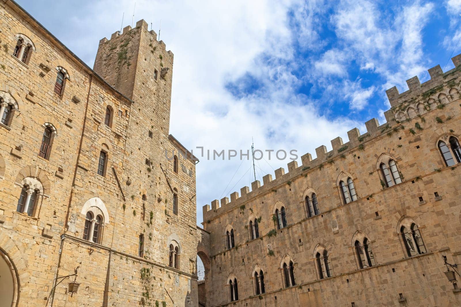 Houses in the Tuscan town of Volterra with a blue sky with clouds in the background. Tuscany, Italy.