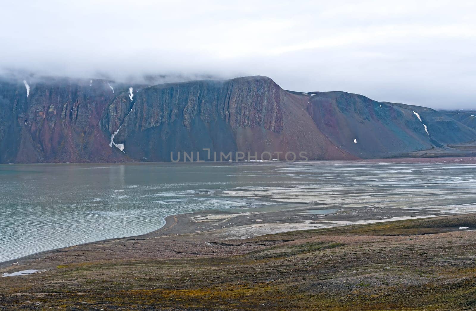 Colorful Cliffs in a Fjord Amdst the Fog at Lomfjorden in the Svalbard Islands