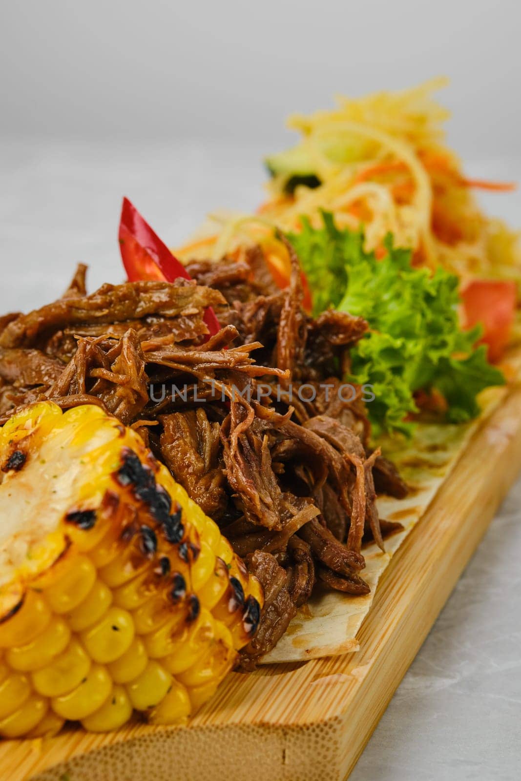 Pulled beef served with grilled corn and pickled cabbage