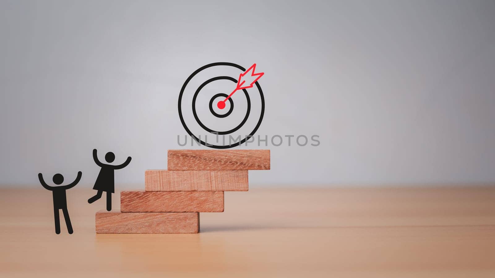 Company employees climb the square wooden steps to reach the dart board. It represents the concept of business strategy and target action plan.