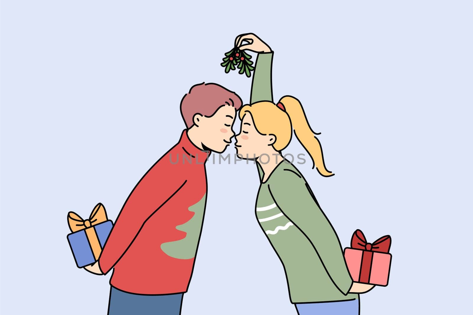 Christmas couple with gift boxes kisses and holds fir cones in hands, preparing to exchange new year presents. Husband and wife in christmas sweaters celebrate winter holidays together