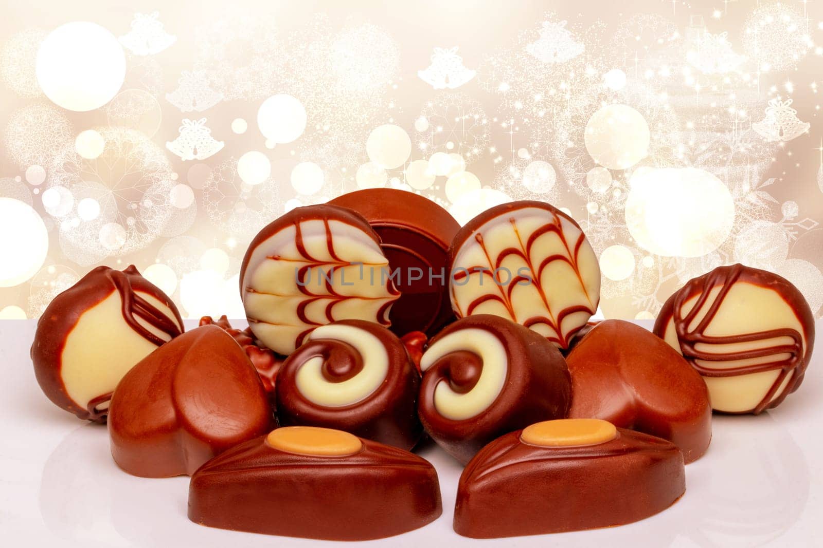 Chocolate candies collection. Beautifully assortment of various swizz chocolate candies scandy, weets on table over abstract bright Christmas background. Copy space.