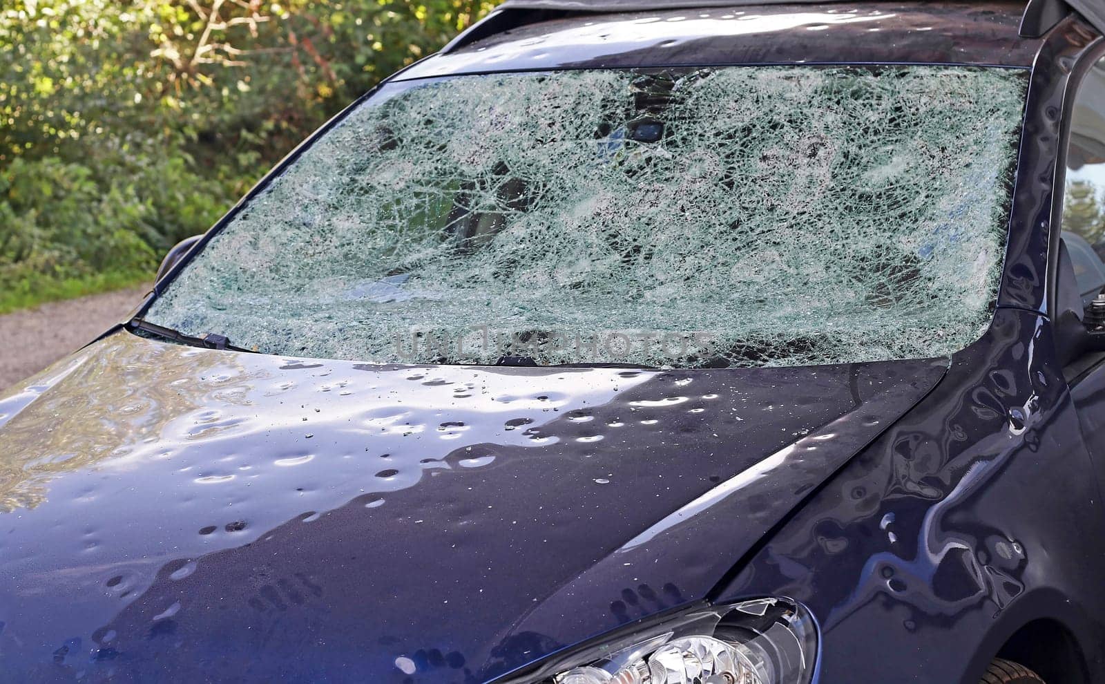 Hail damage to a car. Large hailstones have completely destroyed a car