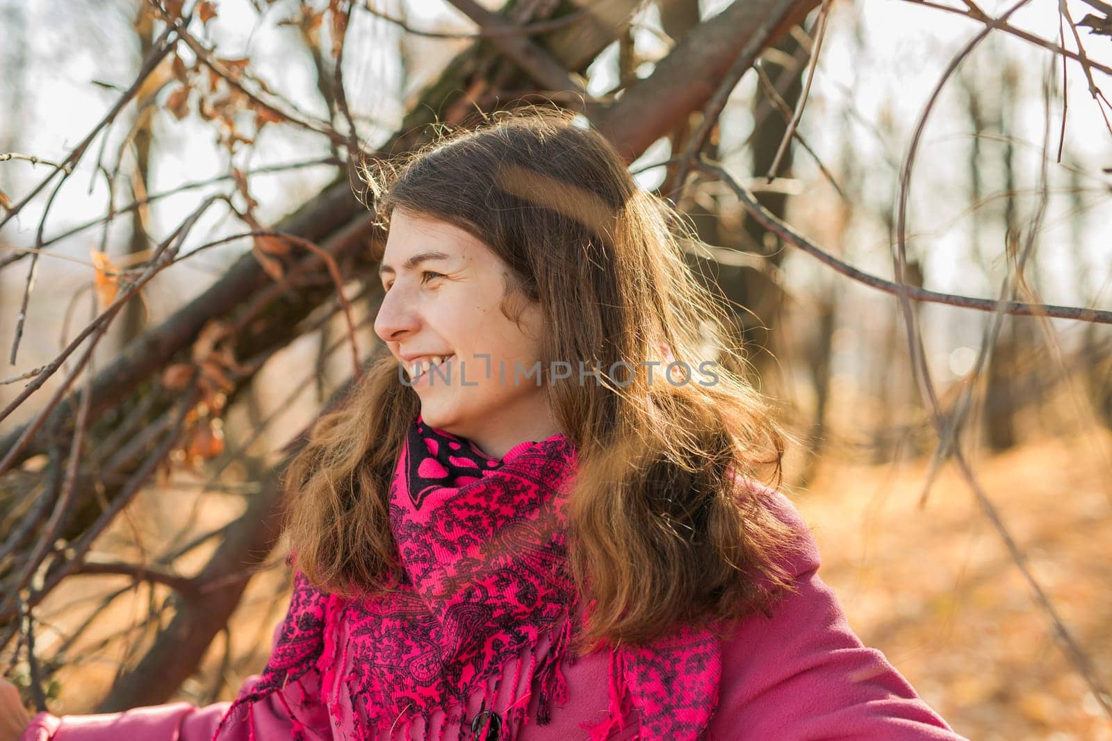 Beautiful happy smiling girl with long hair wearing black hat and pink jacket posing in autumn park. Outdoor portrait day light. Autumn mood concept. Copy empty space for text.