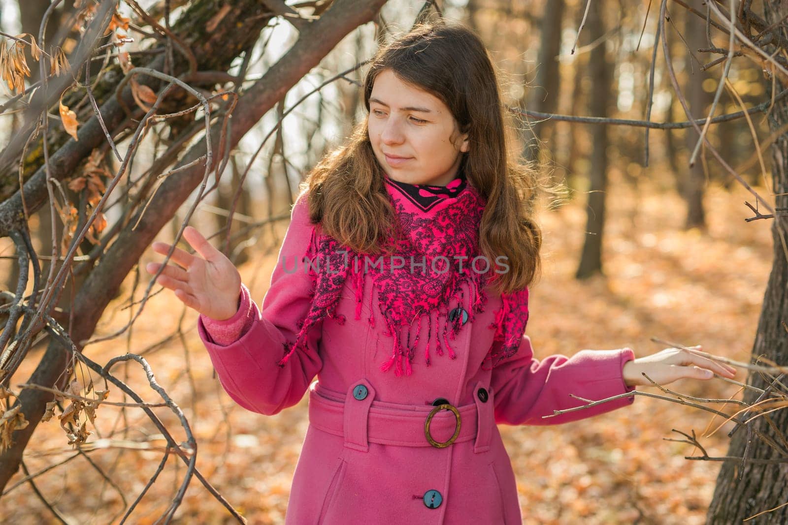 Beautiful happy smiling girl with long hair wearing black hat and pink jacket posing in autumn park. Outdoor portrait day light. Autumn mood concept. Copy empty space for text.