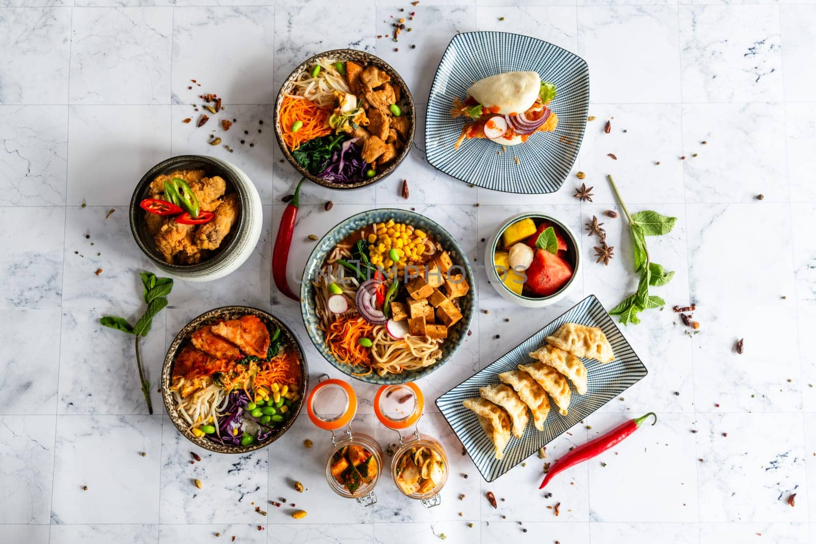 An assortment of well-served Chinese food. Chinese noodles, fried rice, dumplings, pedestrian duck, dim sum, spring rolls. Famous Chinese cuisine on the table. View from above. Chinese restaurant concept. Asian banquet