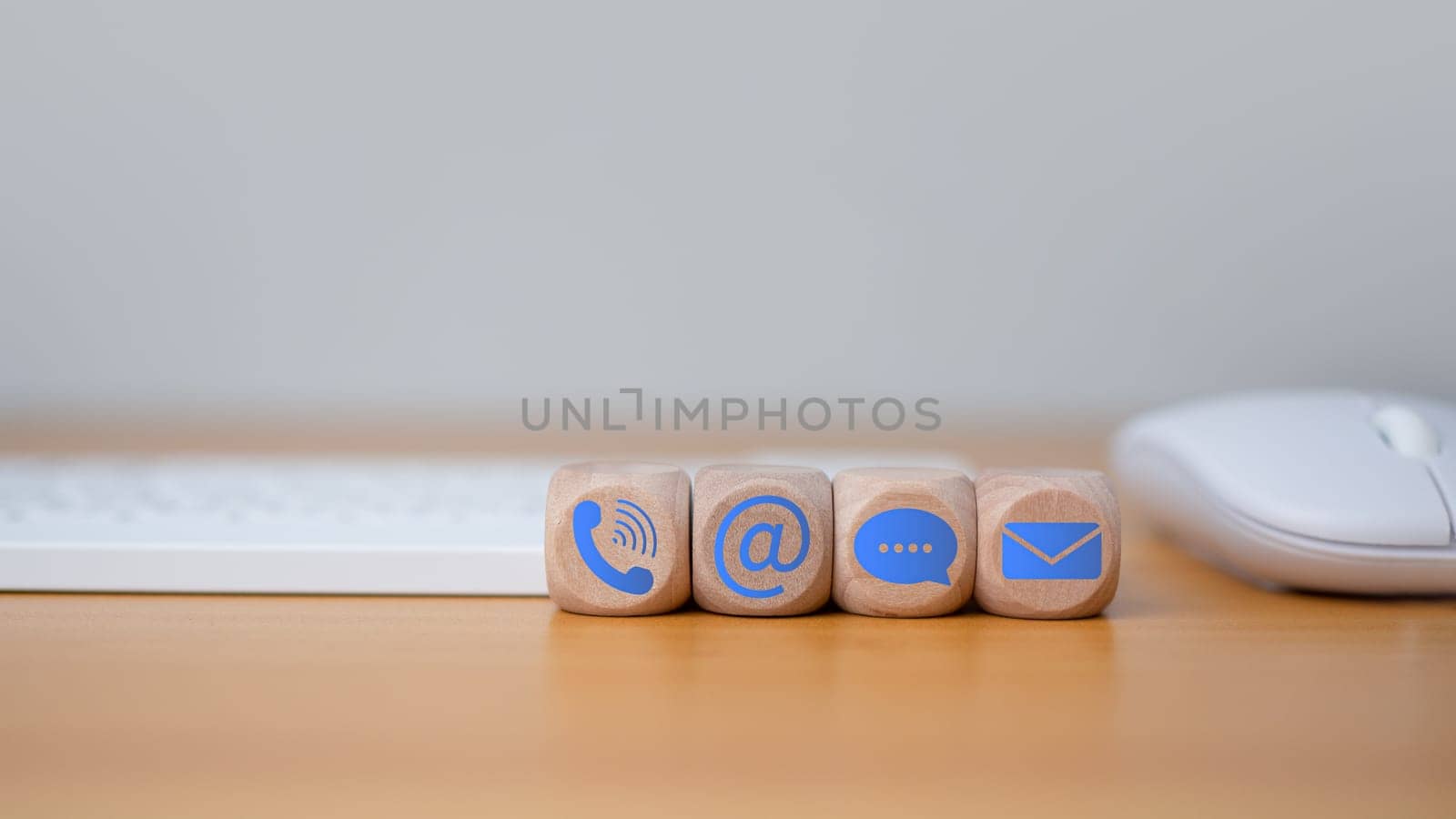 Contact us website page or email marketing concept, customer support hotline, contact us, Keyboard and mouse placed on wooden background with email icons, phone, address, chat message.