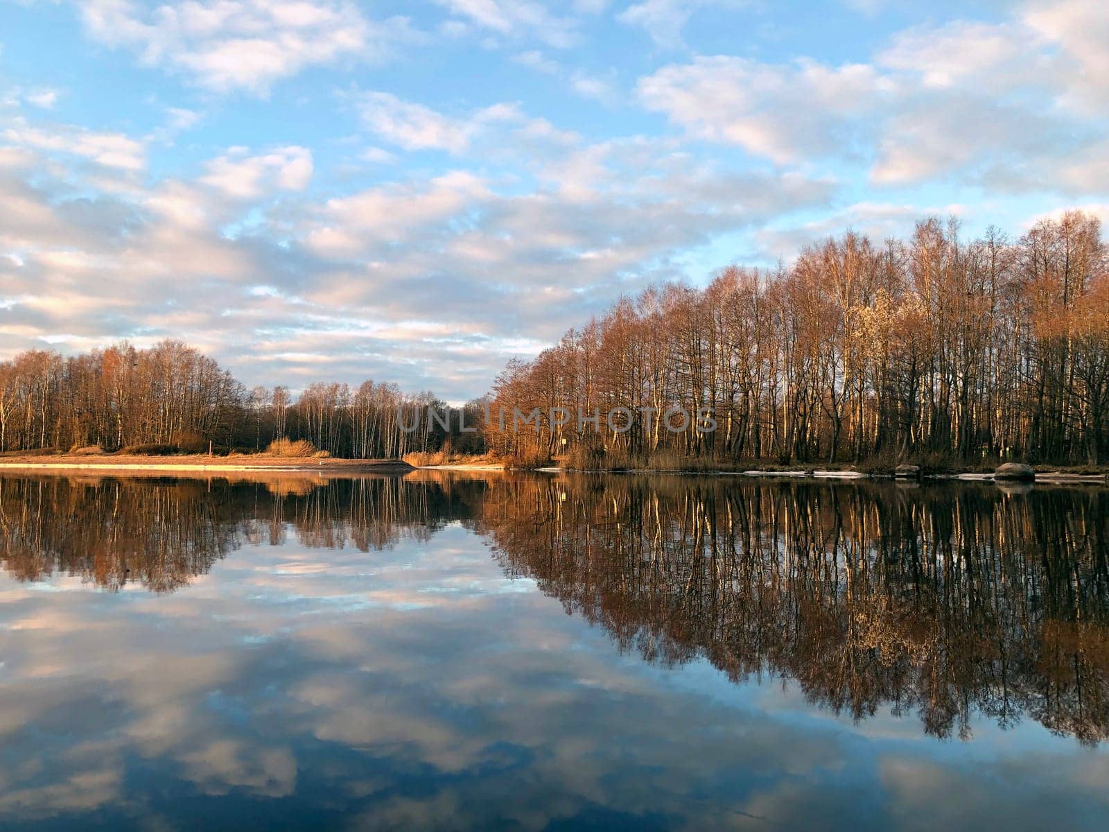 golden hour, wonderful autumn landscape by the river, beautiful reflection of the sky and forest in the water