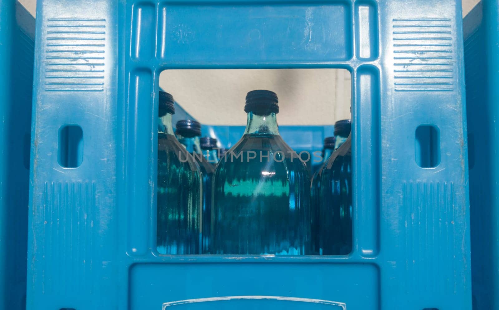 Glass bottled water on his blue box. Selective focus