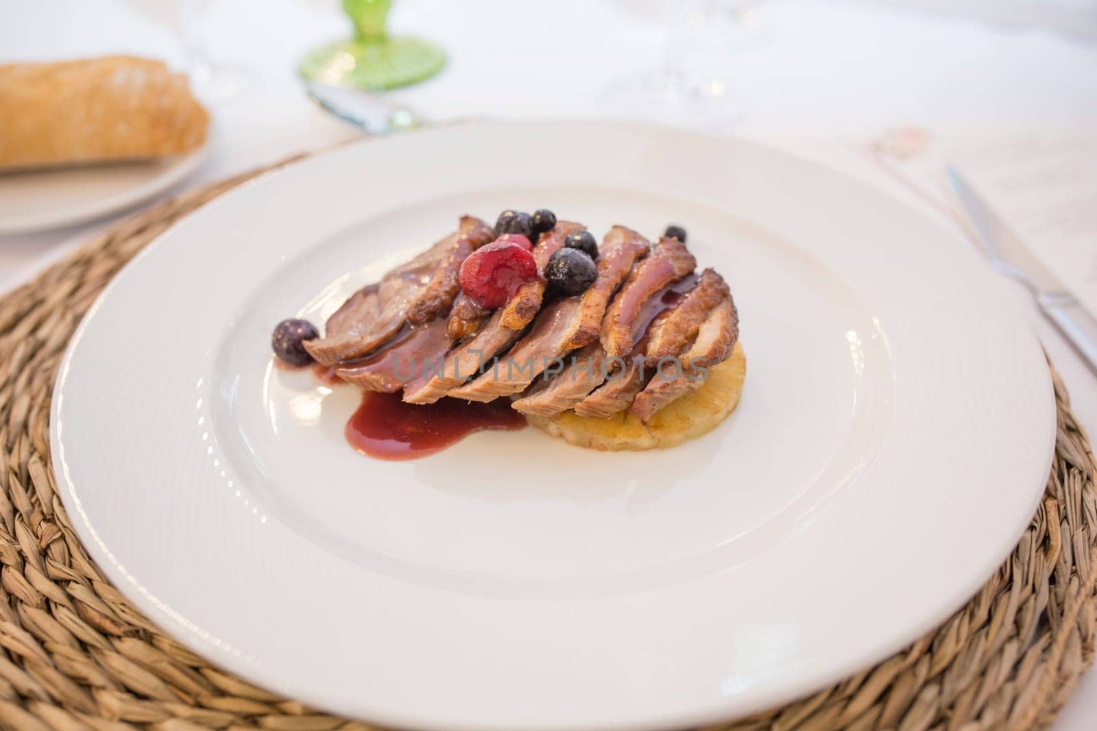 Iberian sirloin fillets cooked with autumn fruits. Plate served over rattan mat