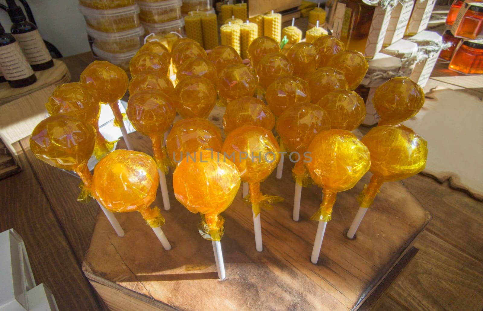 Honey lollipops displayed in a traditional market stall. Healthy candy concept