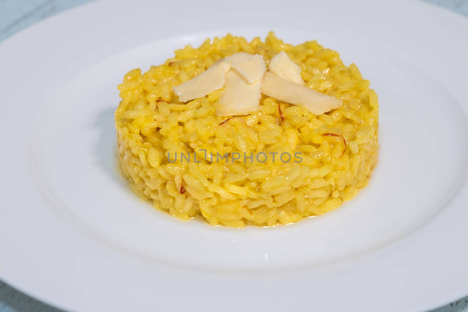 Portion of saffron risotto on the white plate