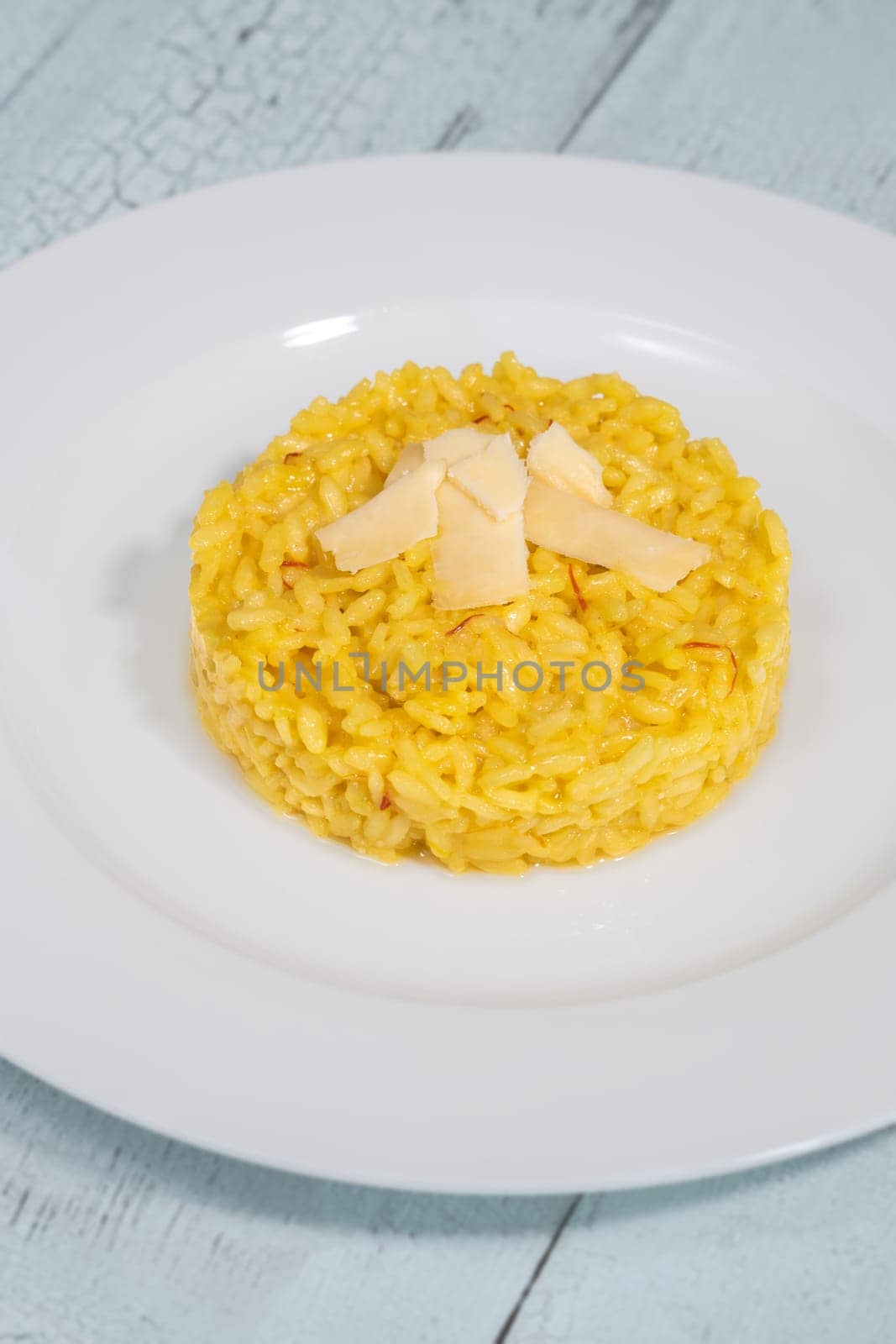 Portion of saffron risotto on the white plate