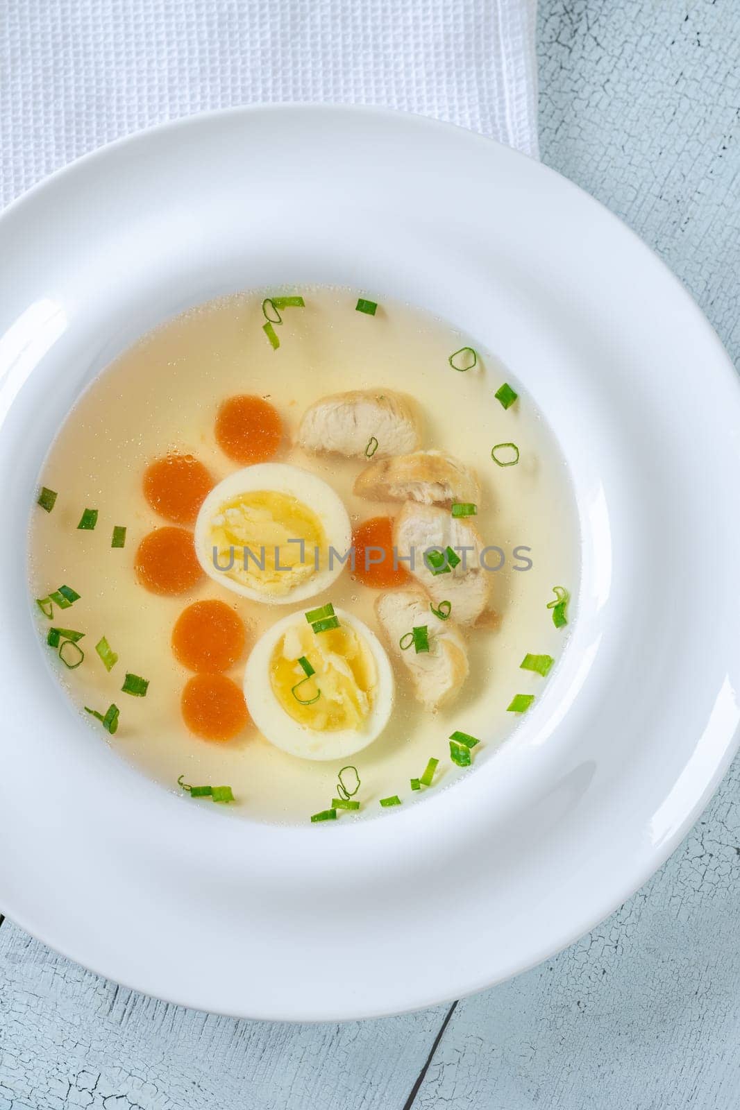 Portion of clear chicken broth in white plate