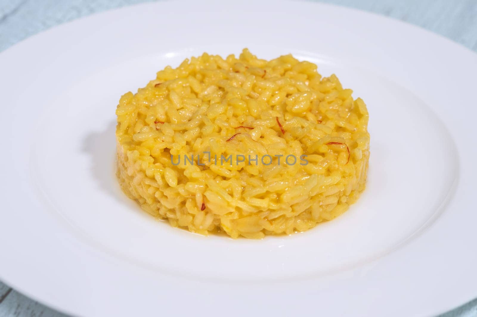 Portion of saffron risotto on the white plate
